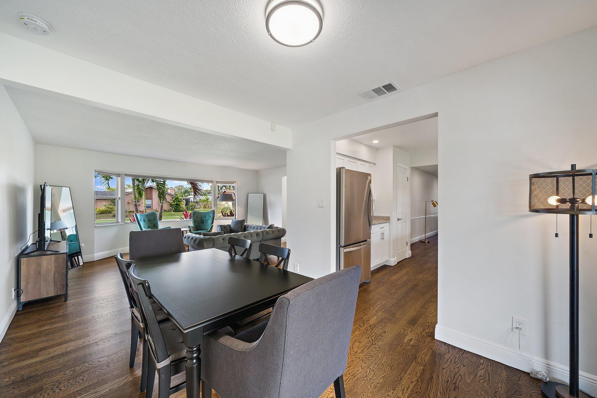 1342 Essex Drive Wellington, FL 33414 - Photo 20 of 58 a view of a dining room with furniture window and wooden floor