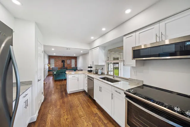 a kitchen with a dining table chairs wooden floor and appliances