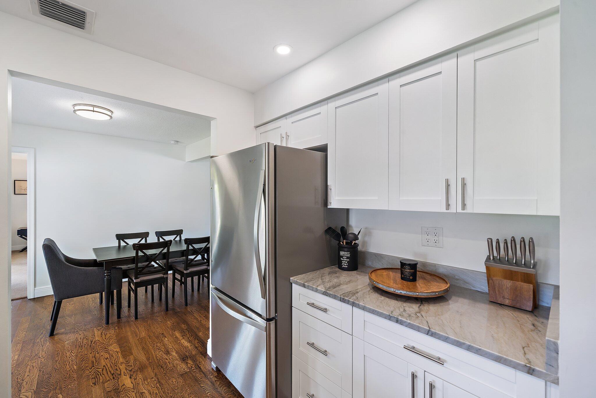 1342 Essex Drive Wellington, FL 33414 - Photo 25 of 58 a kitchen with stainless steel appliances granite countertop a refrigerator a sink a stove and white cabinets