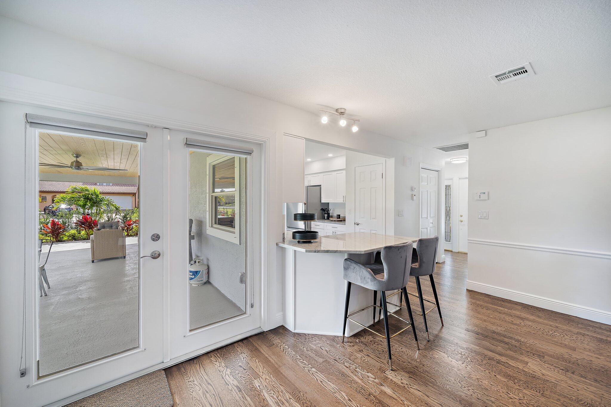 1342 Essex Drive Wellington, FL 33414 - Photo 29 of 58 a view of a dining room with furniture and wooden floor