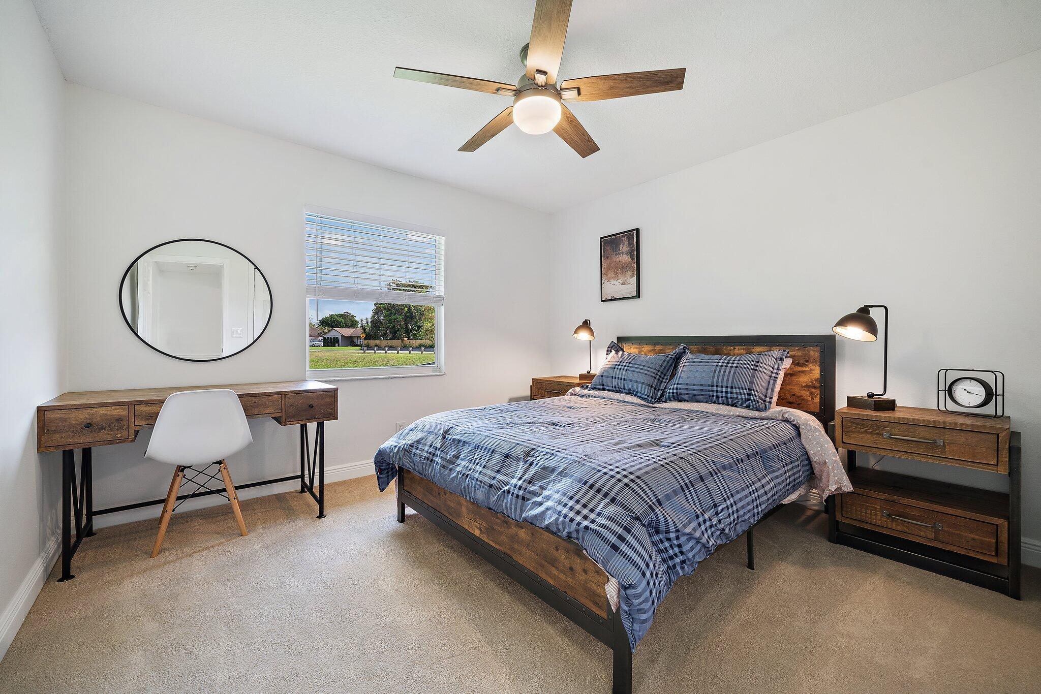 1342 Essex Drive Wellington, FL 33414 - Photo 36 of 58 a bedroom with a bed a dresser and a chandelier