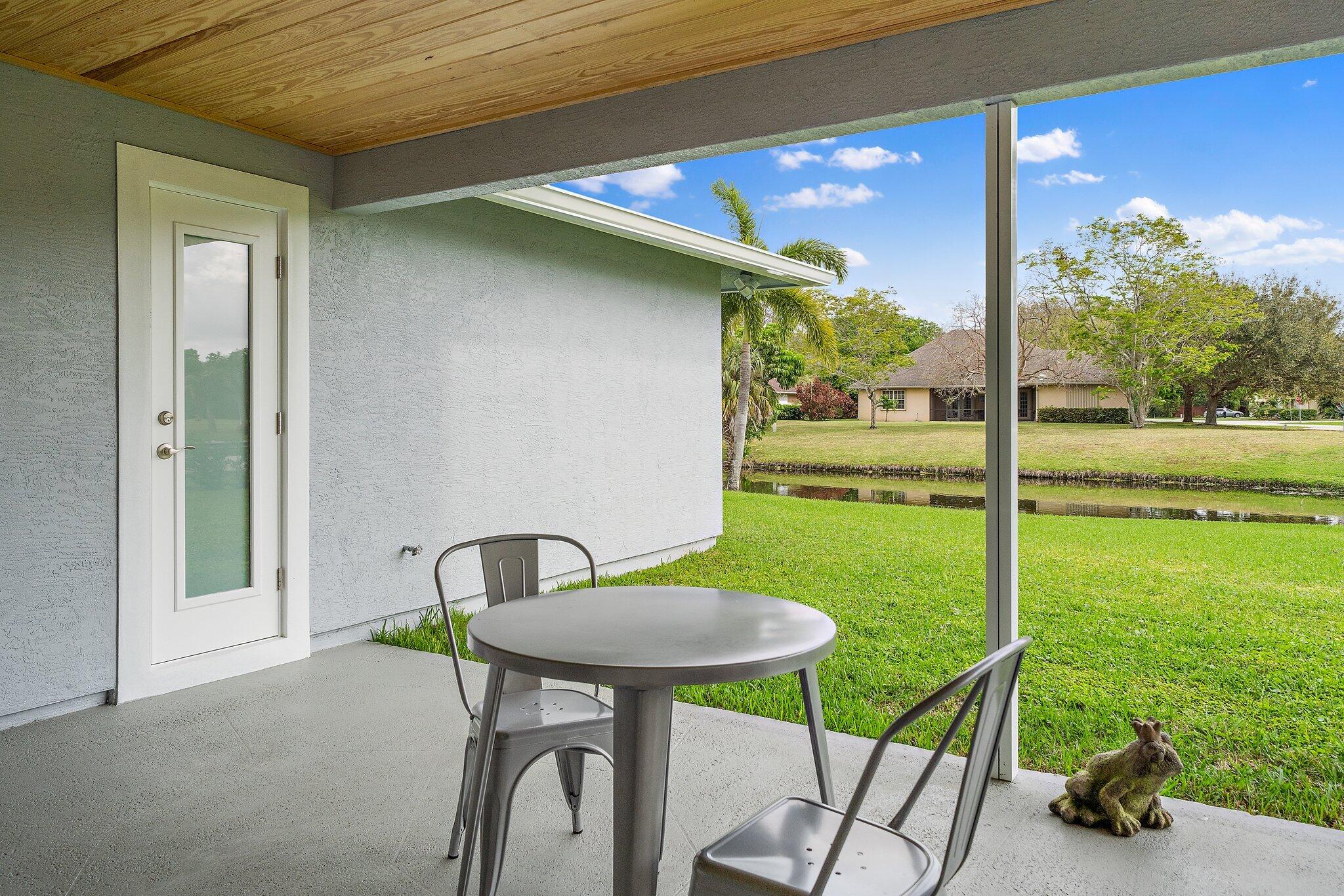 1342 Essex Drive Wellington, FL 33414 - Photo 49 of 58 a view of a chair and table in patio next to a yard