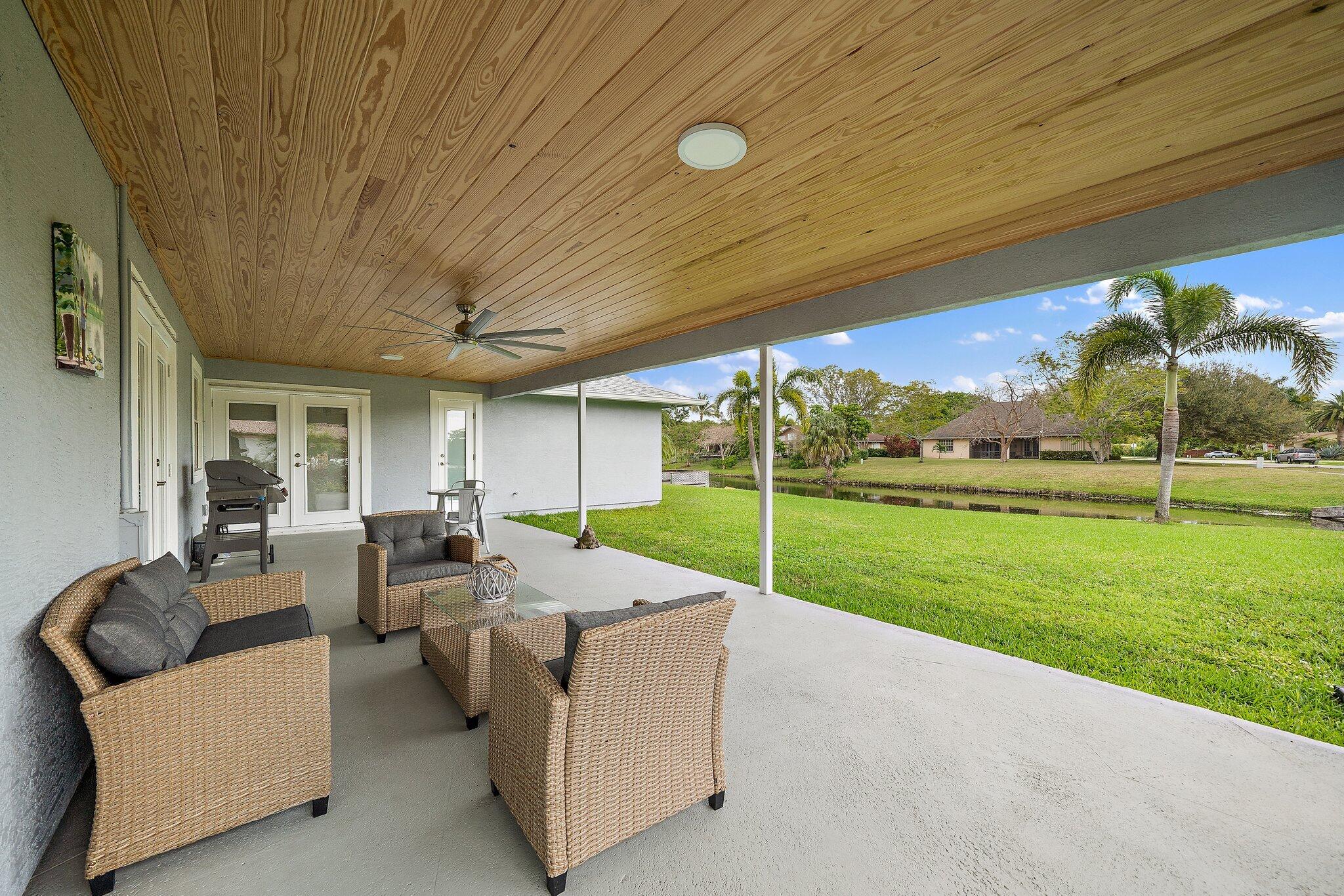 1342 Essex Drive Wellington, FL 33414 - Photo 51 of 58 a patio with table and chairs and garden
