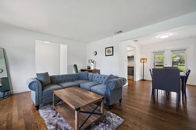 a living room with furniture wooden floor and a flat screen tv