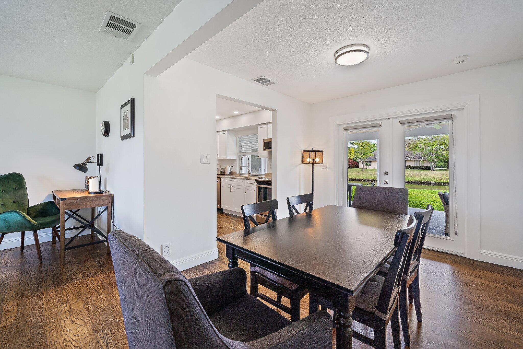 1342 Essex Drive Wellington, FL 33414 - Photo 9 of 58 a view of a dining room with furniture and wooden floor
