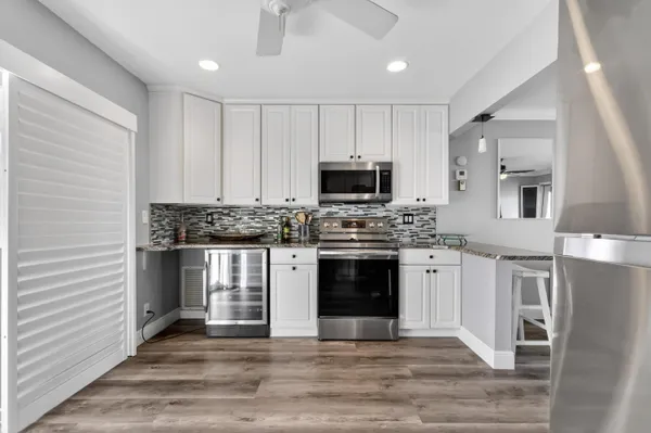 a kitchen with granite countertop a stove top oven and cabinets
