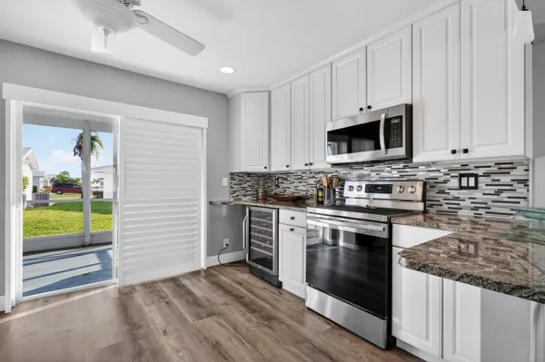 a kitchen with stainless steel appliances granite countertop a stove a sink and a microwave