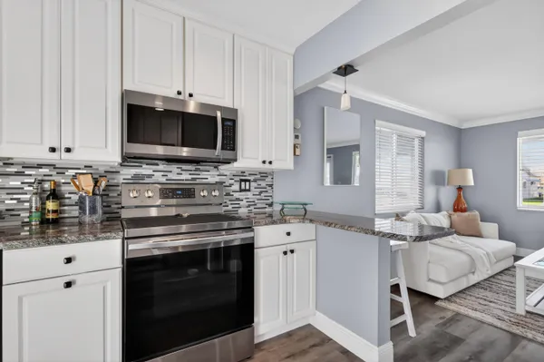 a kitchen with stainless steel appliances a stove microwave and cabinets