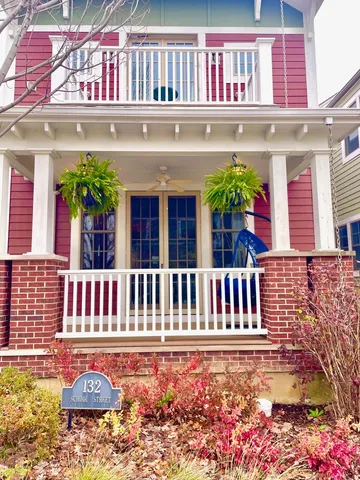 a view of a brick house with potted plants and a table