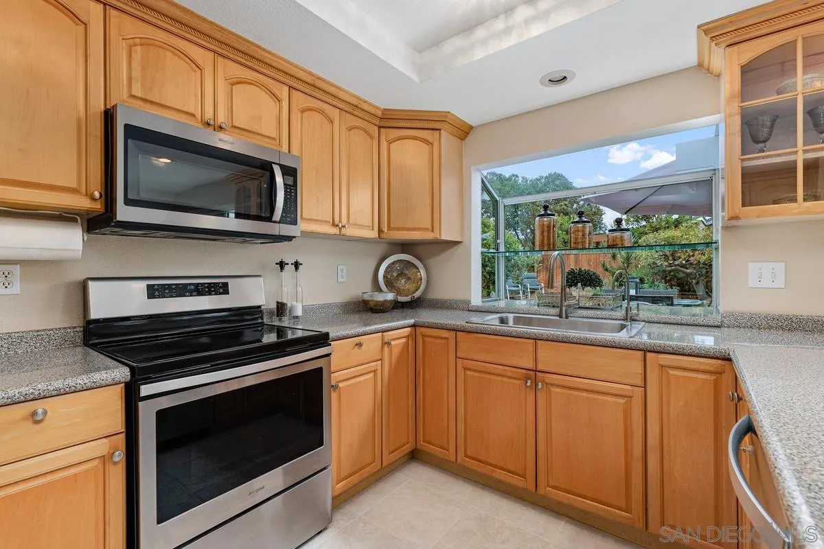 505 Willowspring Drive North Encinitas, CA 92024 - Photo 14 of 47 a kitchen with stainless steel appliances granite countertop a stove microwave and cabinets