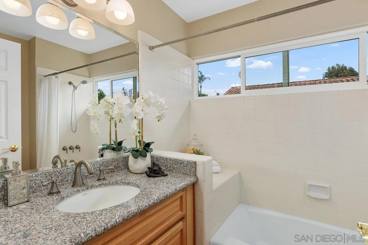 505 Willowspring Drive North Encinitas, CA 92024 - Photo 21 of 47 a bathroom with a granite countertop sink a mirror and shower