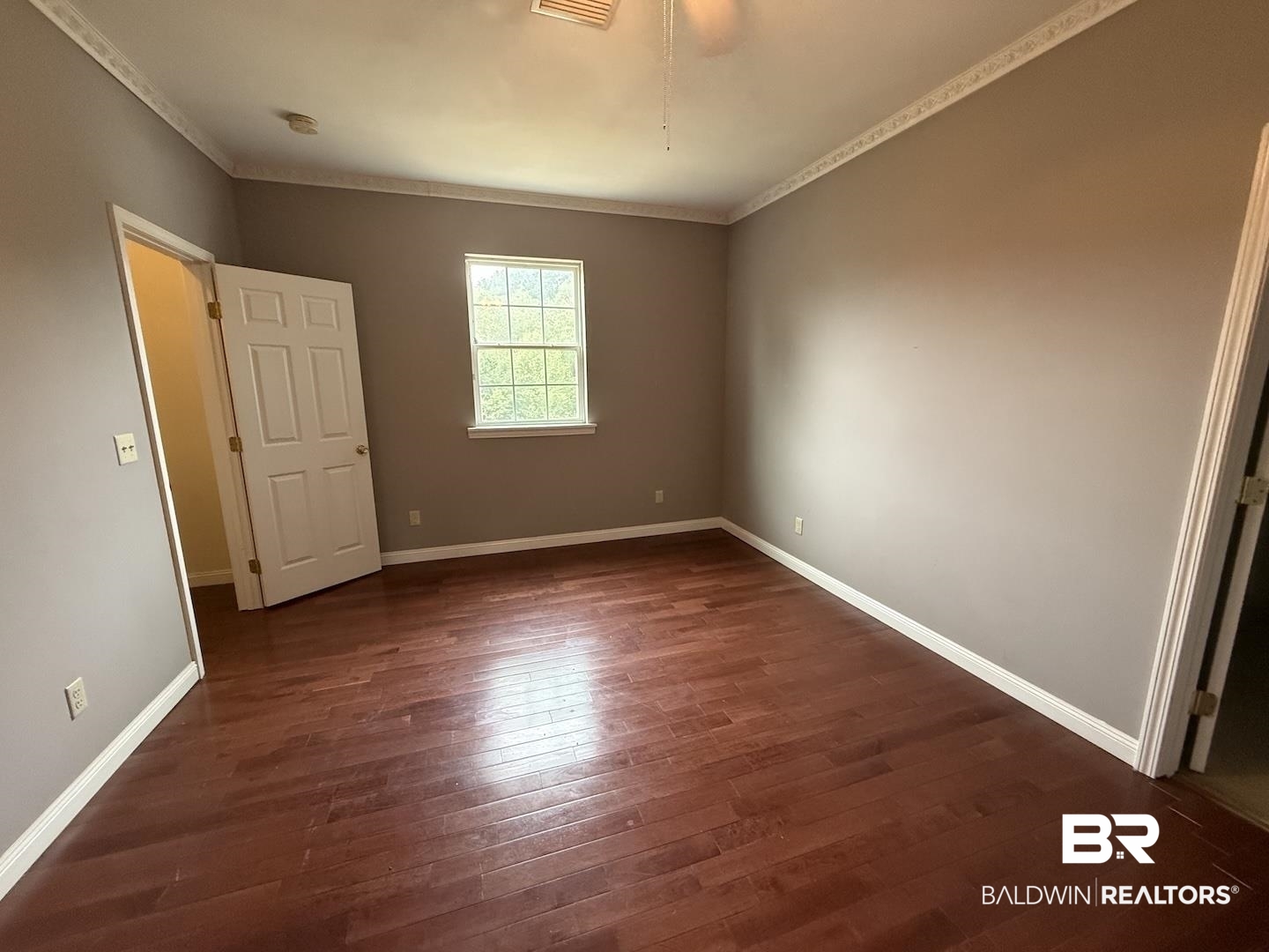 99 Cemetery Street Uriah, AL 36480 - Photo 8 of 13 Unfurnished bedroom featuring dark wood-style flooring, ornamental molding, and a ceiling fan