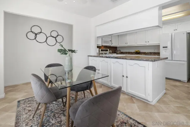 a living room with stainless steel appliances kitchen island granite countertop a stove a sink and a refrigerator