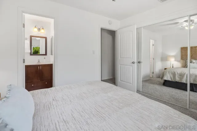 a spacious bedroom with a bed and a mirror