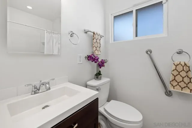 a bathroom with a sink a toilet and mirror
