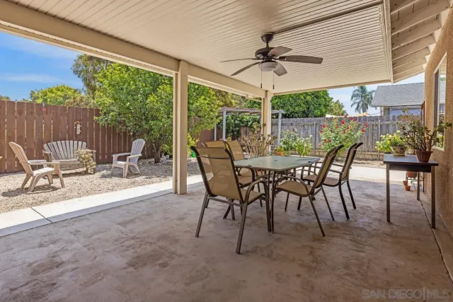 a view of a patio with a table chairs and a backyard