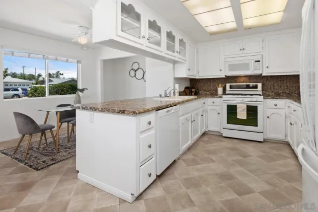 a kitchen with stainless steel appliances granite countertop a stove and cabinets