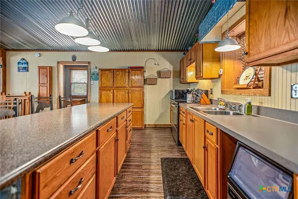 a view of a kitchen with stainless steel appliances granite countertop a sink and cabinets