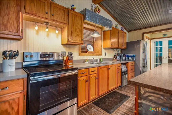 a kitchen with stainless steel appliances granite countertop a stove a sink and a microwave