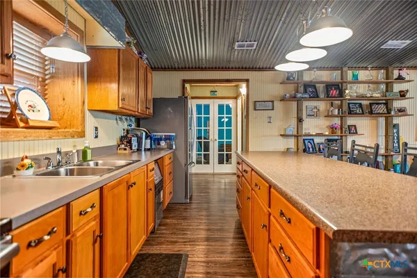 a kitchen with stainless steel appliances granite countertop lots of counter top space and wooden floor