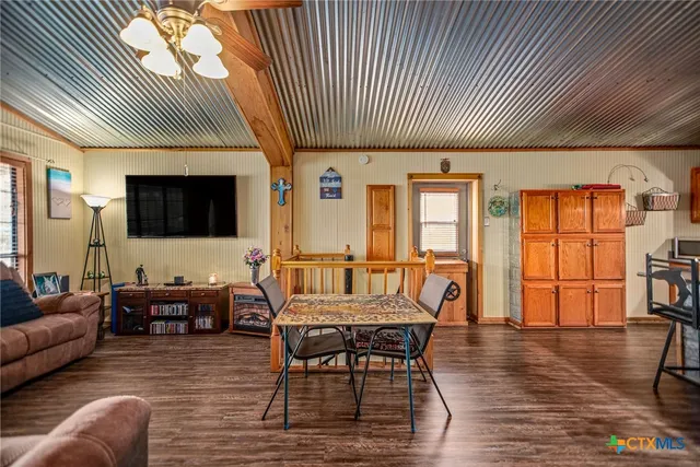 a kitchen with stainless steel appliances granite countertop a stove a refrigerator and a dining table with wooden floors