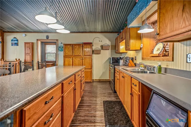 a kitchen with stainless steel appliances granite countertop a stove a sink and a microwave