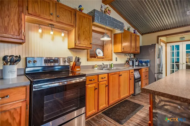 a kitchen with stainless steel appliances granite countertop lots of counter top space and wooden floor