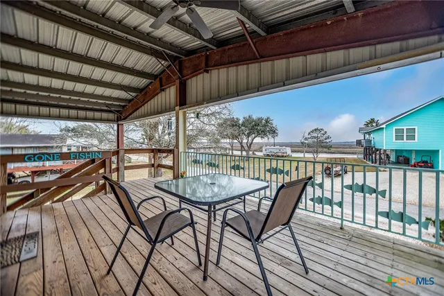 a view of a balcony with chairs and wooden floor
