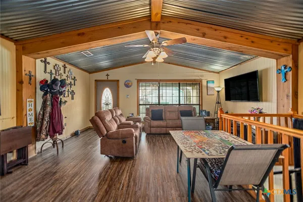 a living room with furniture a flat screen tv and a chandelier