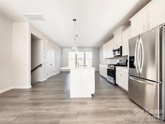 a kitchen with white cabinets and white appliances