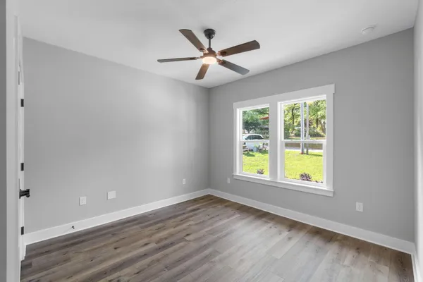 a view of a hallway with wooden floor and closet