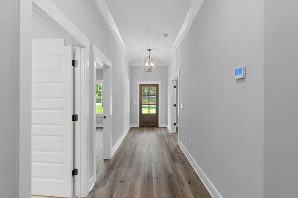a view of a room with wooden floor and kitchen view