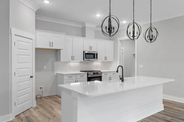 a kitchen with white cabinets and appliances