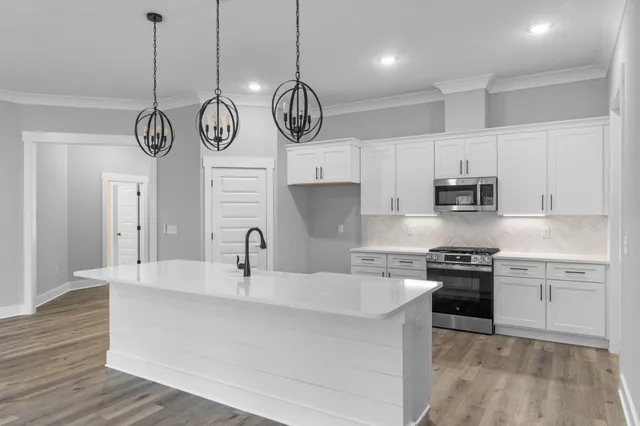 a kitchen with white cabinets and appliances