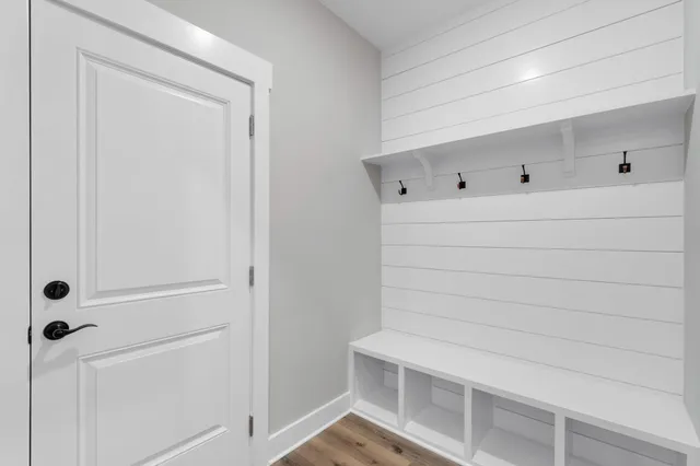 an empty room with wooden floor ceiling fan and windows