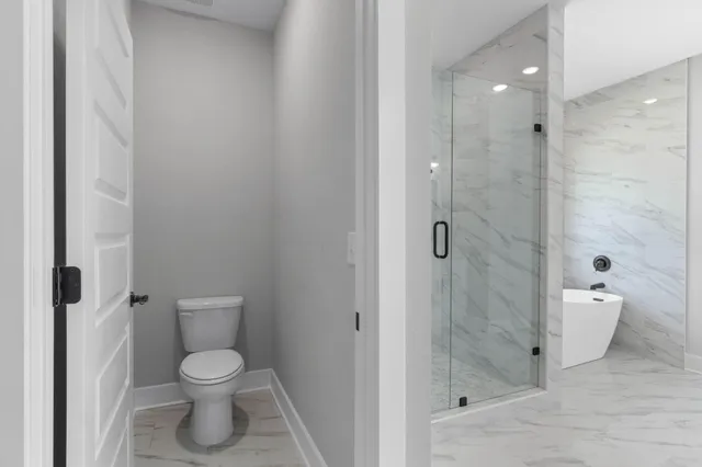 a bathroom with a tub shower sink vanity and a toilet