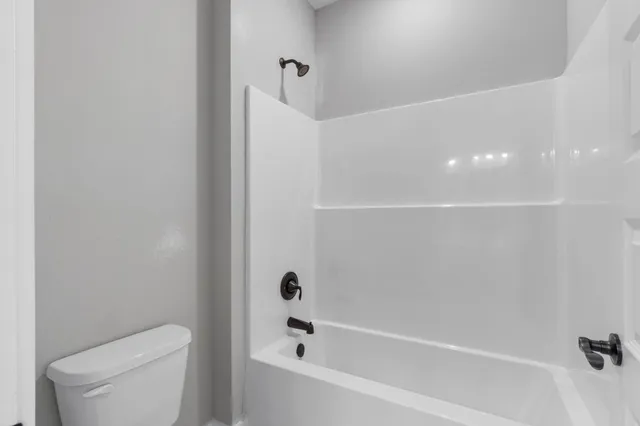 a view of a white house with a yard table and chairs