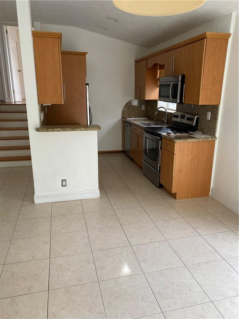 1430 Northeast 4th Court Boca Raton, FL 33432 - Photo 12 of 15 a kitchen with a sink a stove and a microwave