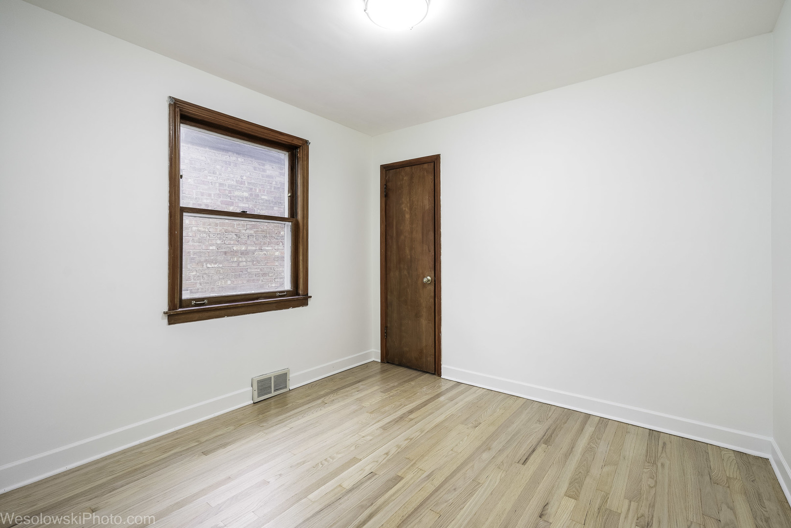 5944 West Foster Avenue Chicago, IL 60630 - Photo 8 of 21 an empty room with wooden floor and windows