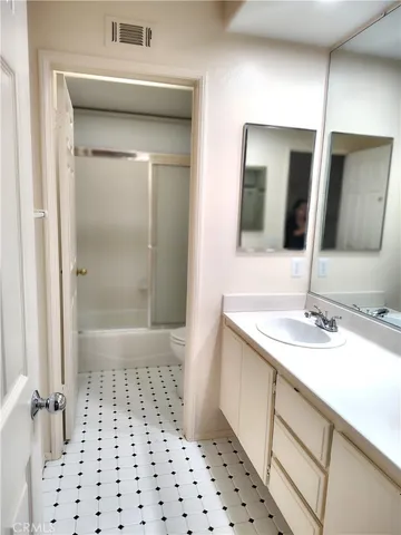a bathroom with a sink a toilet a mirror and shower