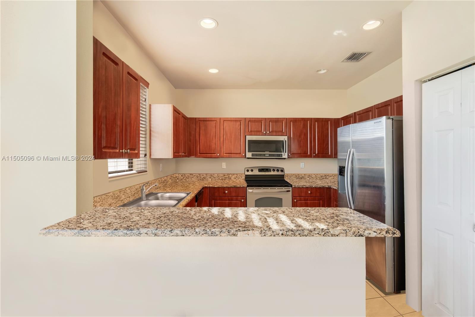 11368 Southwest 238th Street Homestead, FL 33032 - Photo 14 of 18 a kitchen with stainless steel appliances granite countertop a sink a stove a refrigerator a washer and dryer