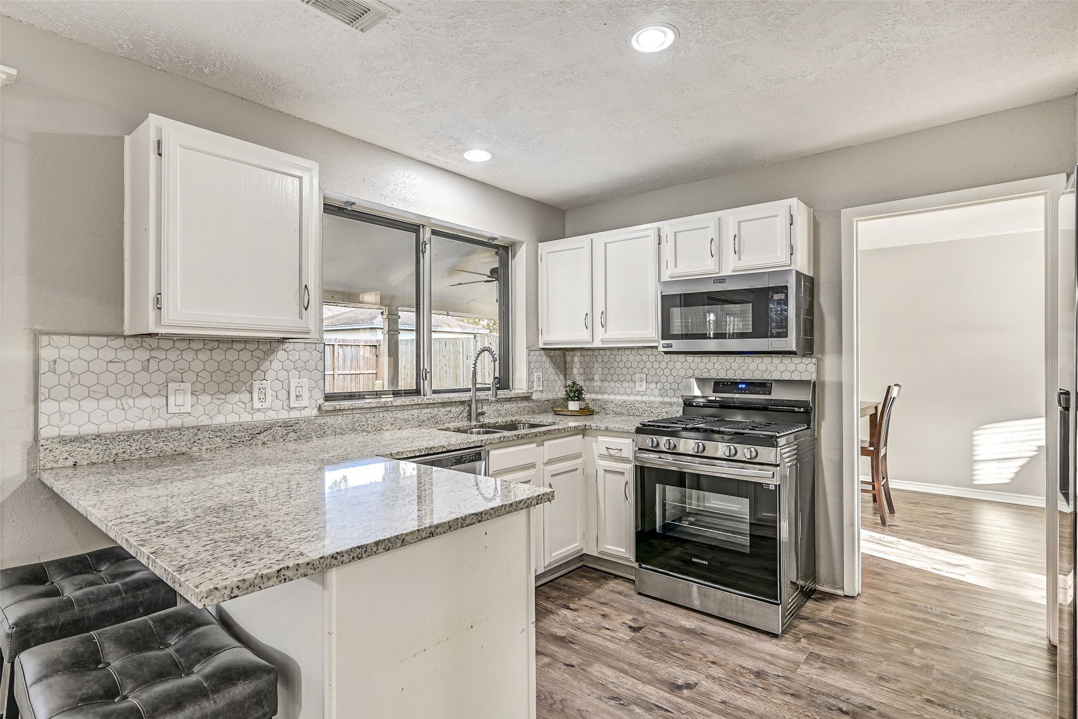 2503 Colleen Drive Pearland, TX 77581 - Photo 7 of 23 a kitchen with stainless steel appliances granite countertop a stove a sink and a microwave
