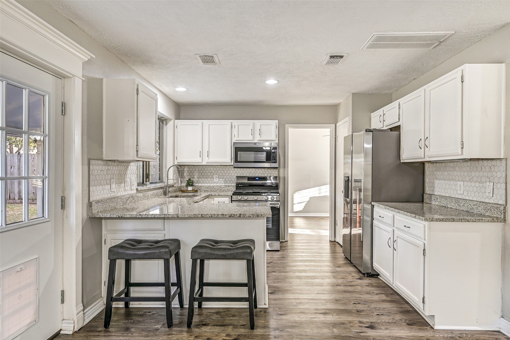 2503 Colleen Drive Pearland, TX 77581 - Photo 8 of 23 a kitchen with stainless steel appliances granite countertop a table chairs sink refrigerator and cabinets