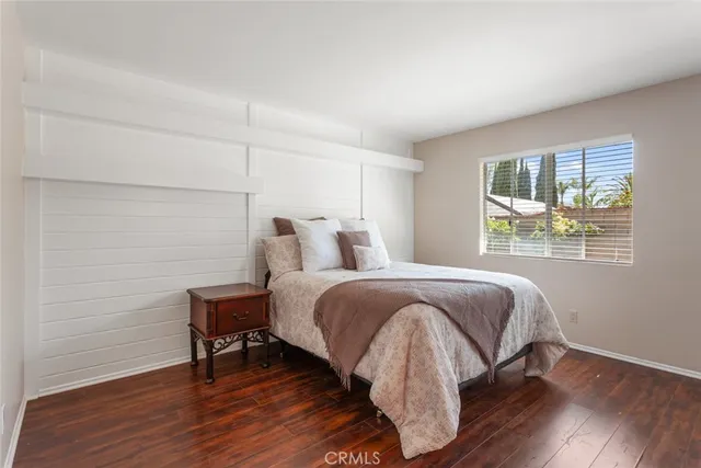 a bedroom with a bed table and a window