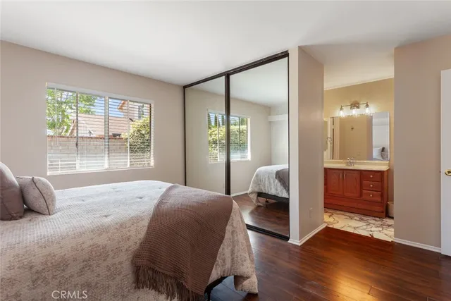 a spacious bedroom with a bed and wooden floor