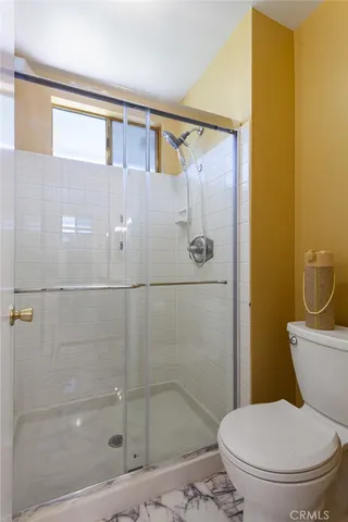 a bathroom with a toilet and a shower