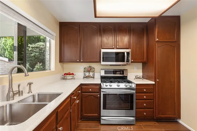 a kitchen with wooden cabinets a sink and a stove with wooden floor