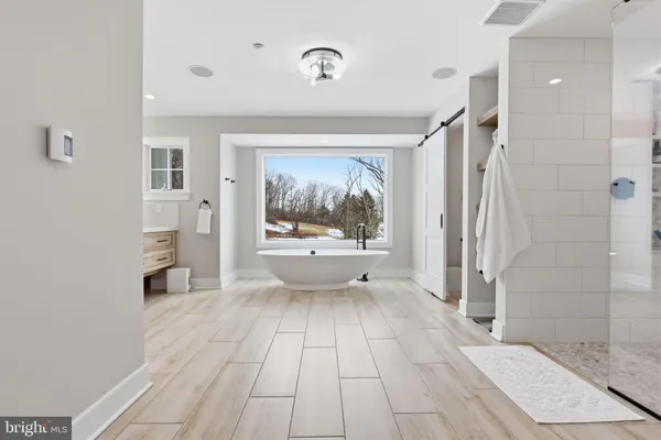 a bathroom with a sink a large mirror and a bathtub