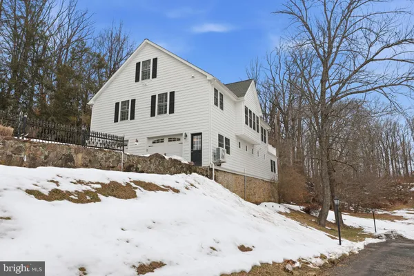 a living room with couches a dining table and chairs with wooden floor