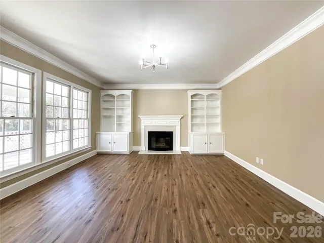 wooden floor fireplace and windows in an empty room
